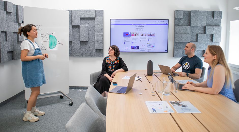 Team collaborating during a meeting with presentation and discussion in a modern office.